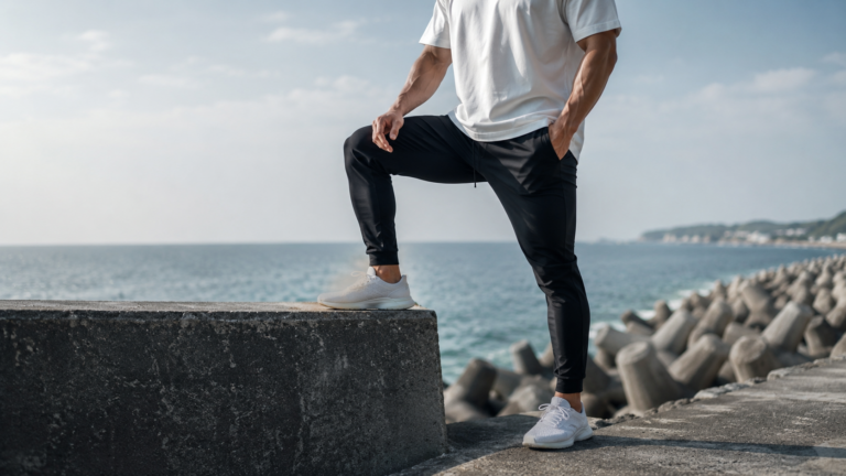 黒いパンツを履いて海辺で脚を上げる男性